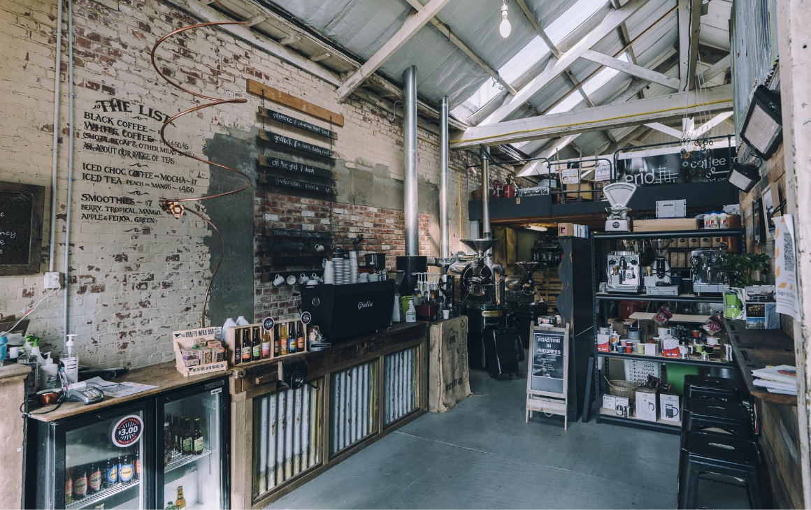 Grid Coffee Roasters, industrial aesthetic building with a variety of coffee beans stacked on the shelves