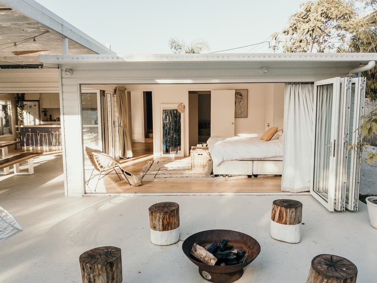 stools around a firepit in front of an open bedroom