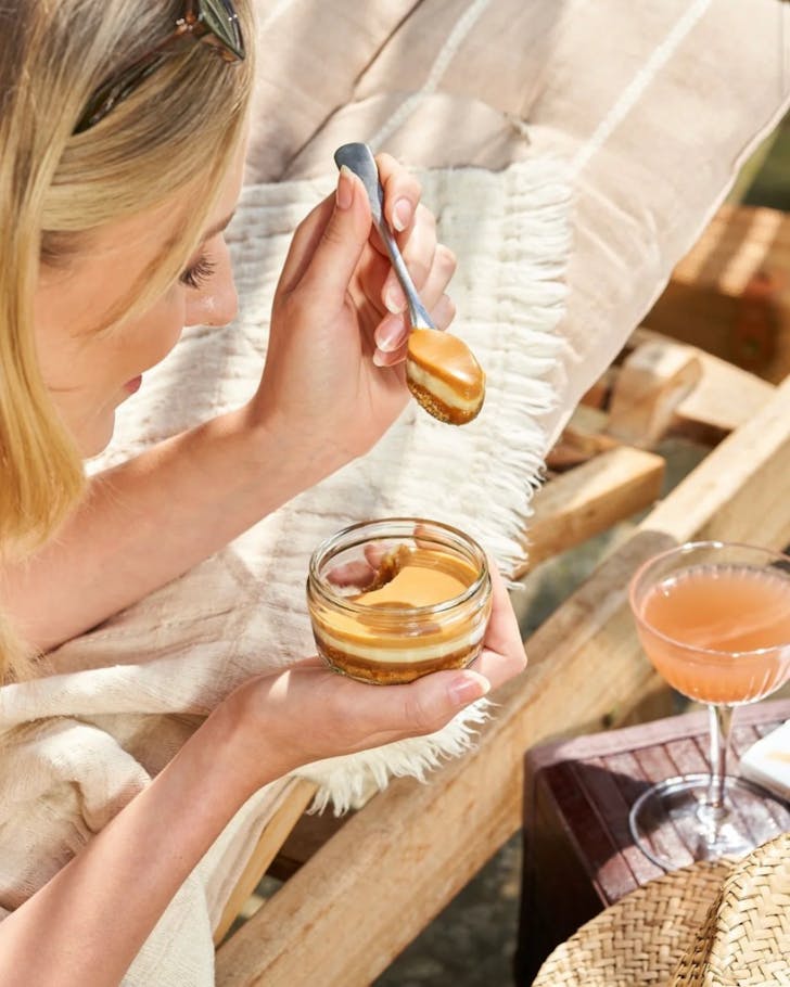 A person excitedly tucks into one of Gu's Salted Caramel cheesecakes. 
