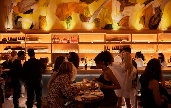 A group of people sitting at a table at one of the best cbdf bars in Melbourne.