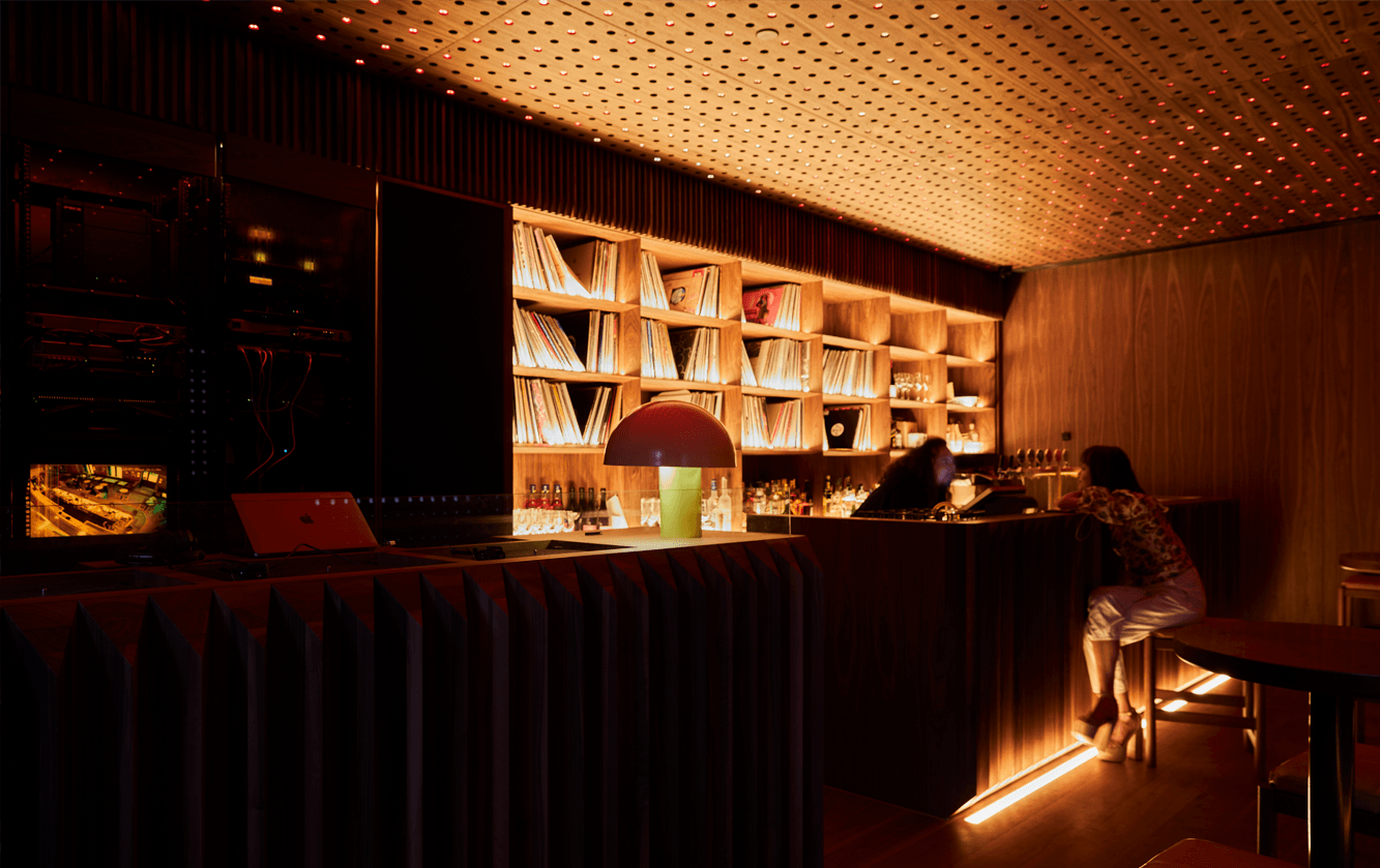 A dim lit bar with records on a shelf at one of the best nightclubs in Melbourne.