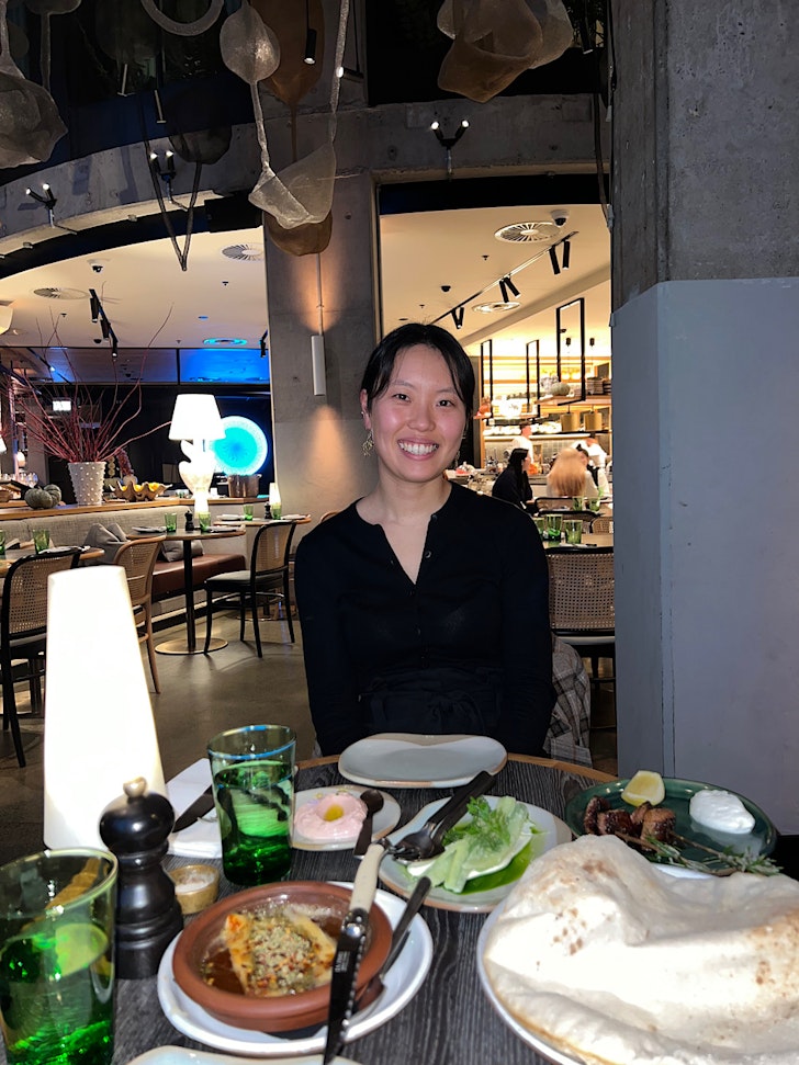 Ha-Young sits at a table laden with food.