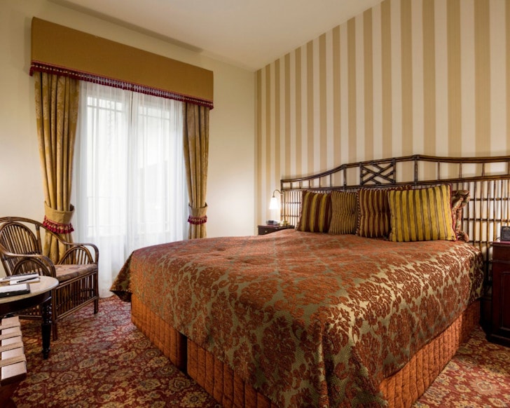 A bedroom with statement wallpaper at Hadley’s Orient Hotel one of the best Hobart hotels