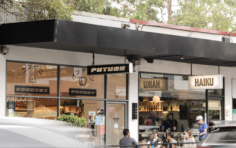 A busy street with the shop front of a camberwell restaurant