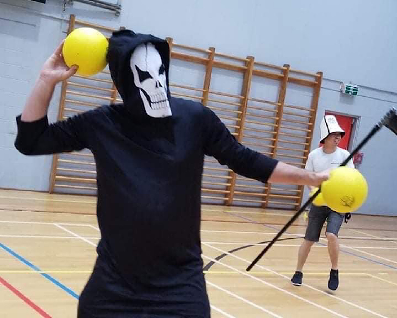 A person dressed as the Grim Reaper prepares to throw a ball at someone in Halloween Dodgeball, one of the best Halloween events in Auckland this year.