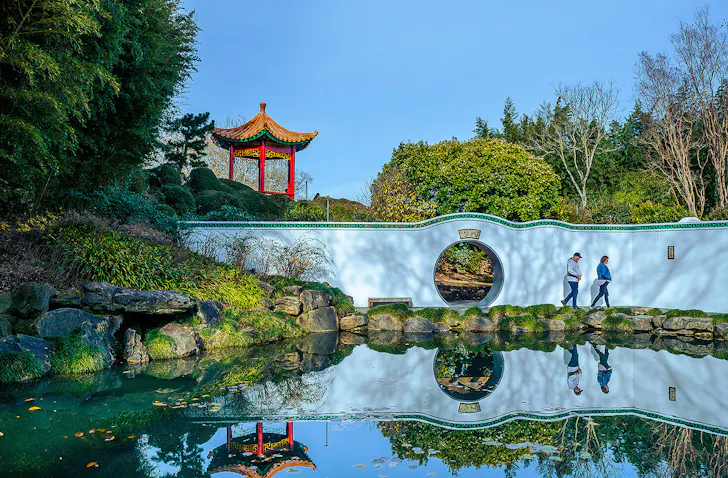 Two people wander about at Hamilton Gardens.