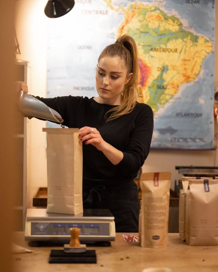 A staff member weighs and bags freshly roasted coffee beans at Hawthorne Coffee Roasters. 