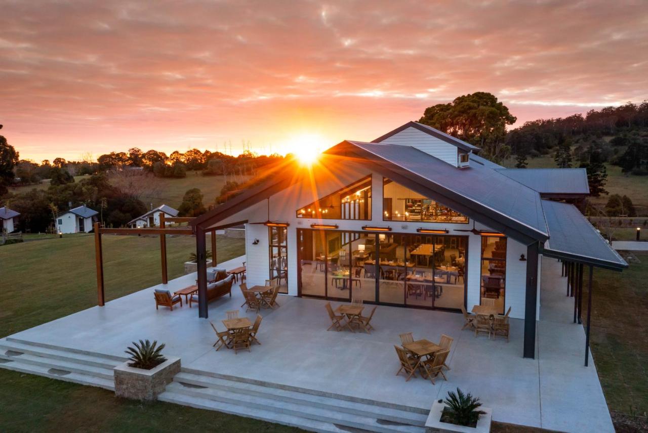 Estate building with outdoor deck area and a sunset in the sky.