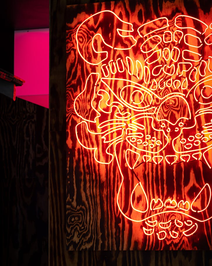 A giant red neon tiger on a black wall.