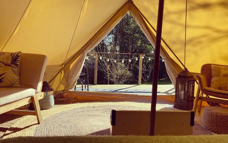 The inside of a tent looking out onto a field, a contender for the top glamping victoria.