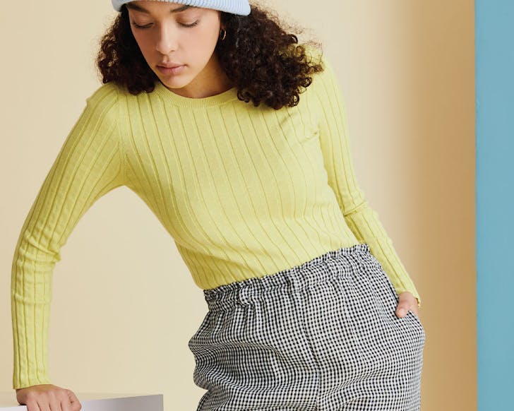 A woman wears a yellow âcakeâ knit long-sleeved top. 