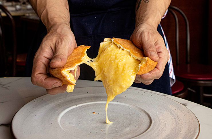 A cheesy toastie being torn apart. 