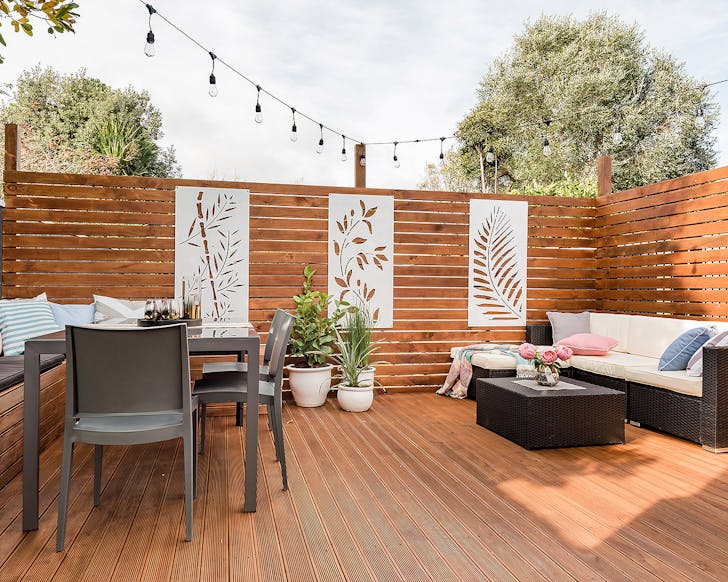 The view of the private outdoor dining area at the Heritage Listed Cottage in Petone, lined with greenery and perfect for entertaining.
