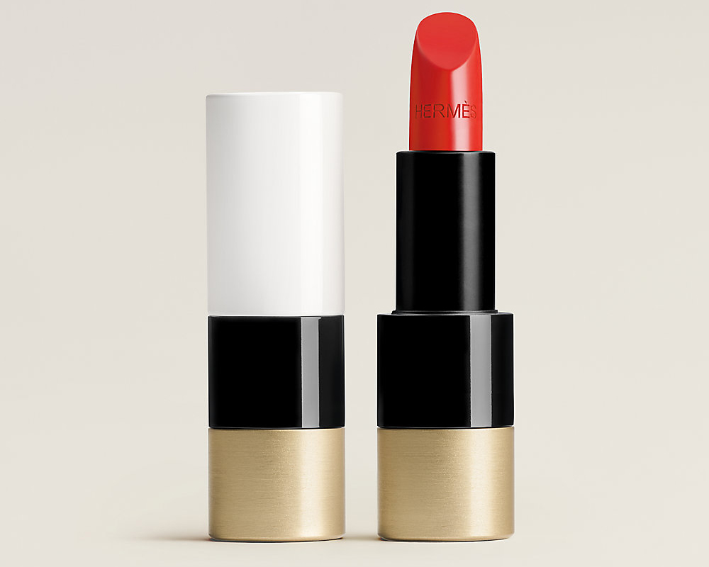 A white, black and gold tube with red lipstick.