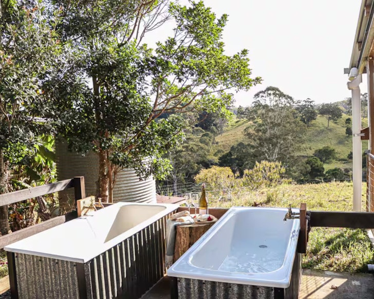 A view of the twin outdoor baths overlooking the countryside at Hidden Creek Cabin Airbnb Sunshine Coast