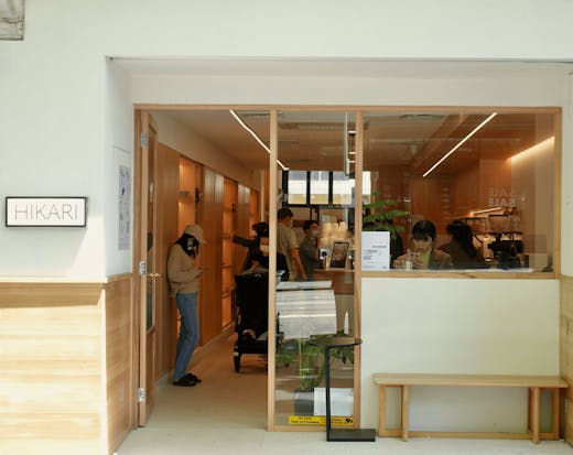 A cafe shopfront with wooden walls inside and a coffee machine up front.
