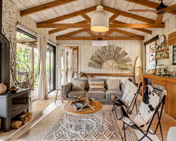 Country-style living room with fireplace and balcony at Hillview Dairy