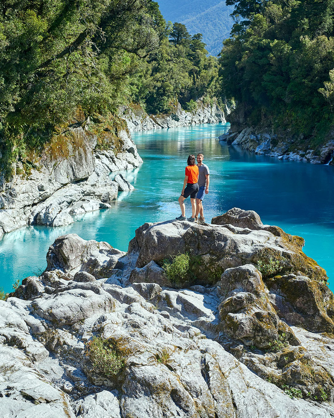 A stunning view of Hokitika Gorge with people scrambling over the rocks.