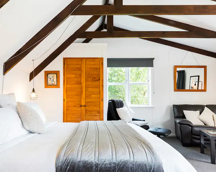 The bedroom with wooden beams at Homestead Cottage one of the best romantic stays near Auckland