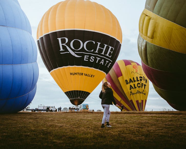 Person surrounded by grounded hot air balloons