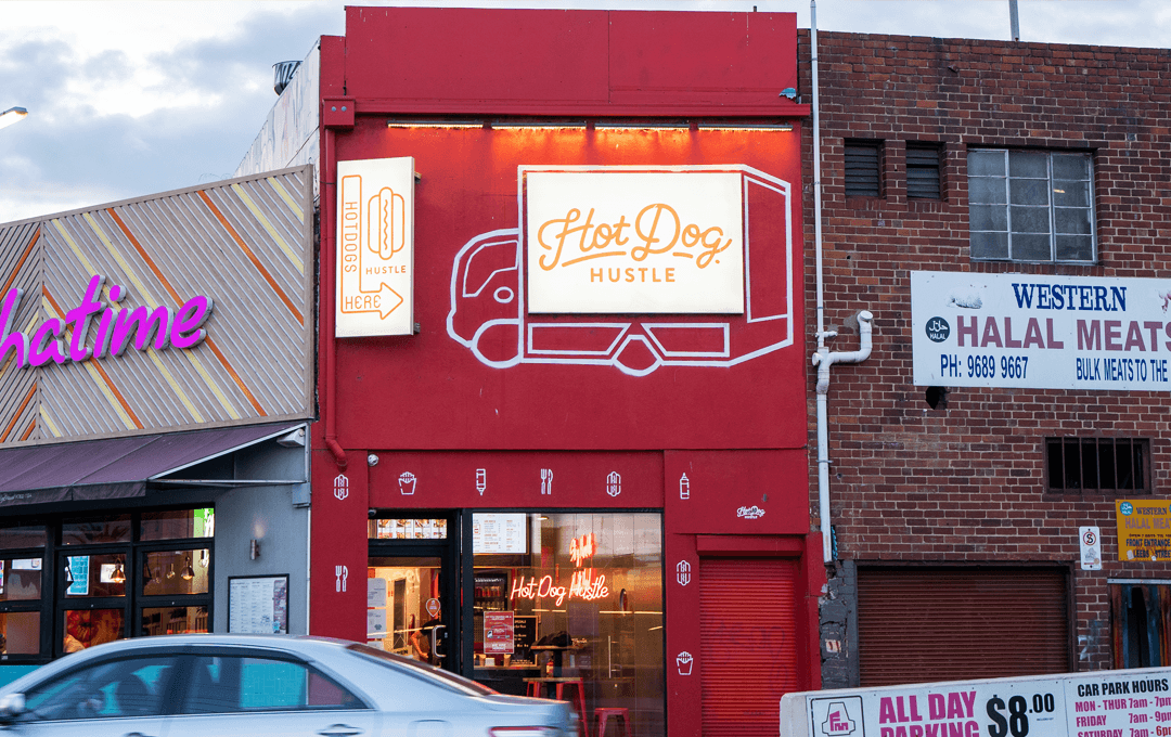 A red shop front with a truck painted on it. 