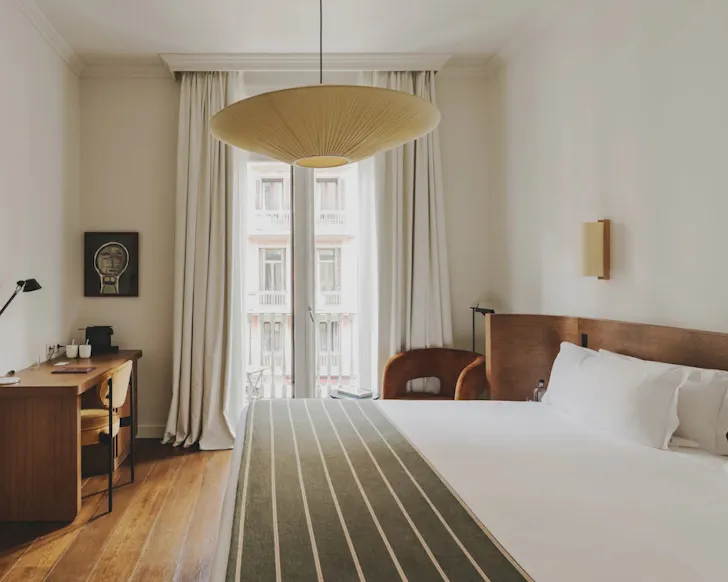A crisp, modern bedroom with warm, timber accents at Hotel Regina in Barcelona.