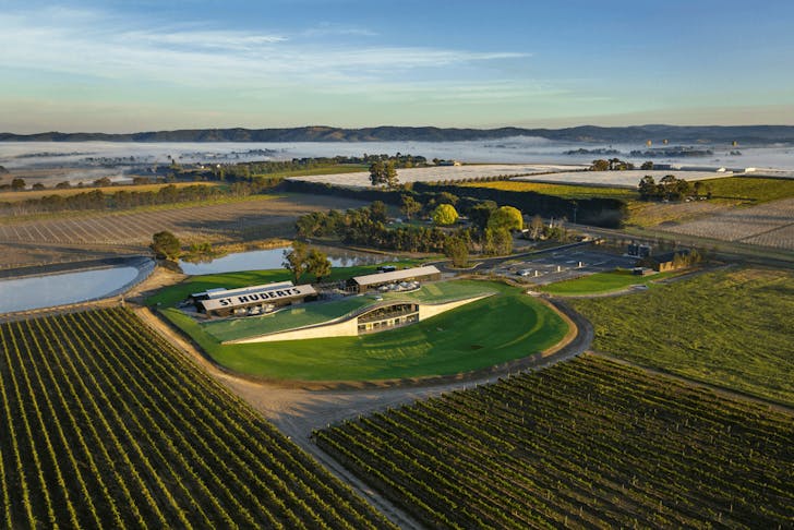 An aerial shot looking over a large vineyard and building. 