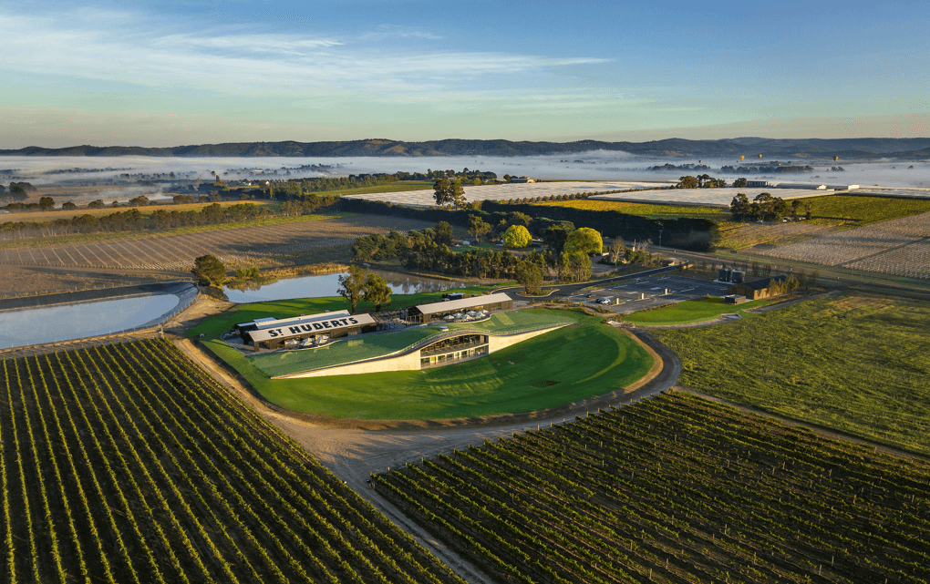 An aerial shot looking over a large vineyard and building. 
