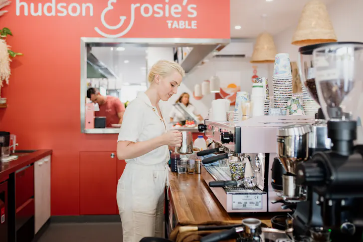 a barista standing at a coffee counter