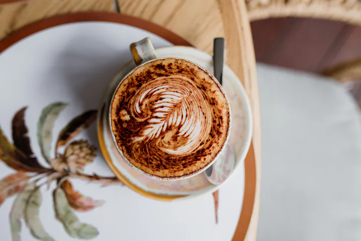 a coffee atop a plate with palm trees
