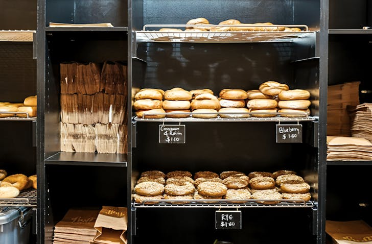 Freshly baked bagels sit on display shelves.