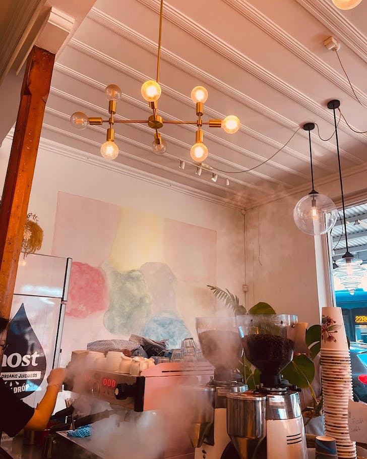 The Little Q team make coffee, steam rises in the air.
