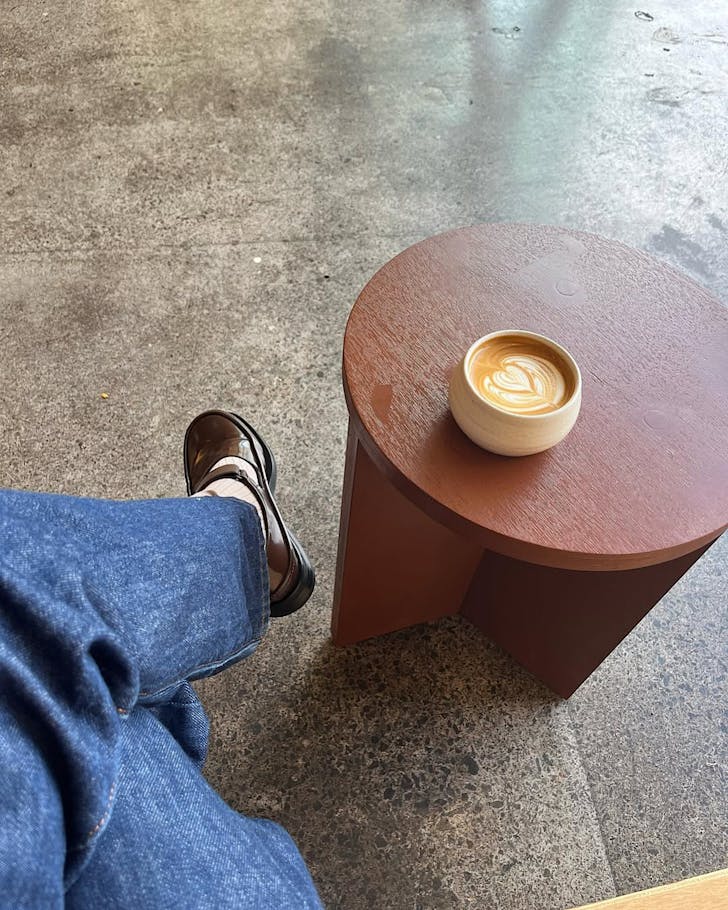 Someone sits in holiday cafe, enjoying a delicious-looking cup of coffee.