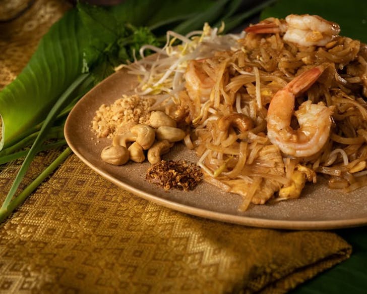 A plate of Golden Silk Thai RestaurantÃ¢ÂÂs Pad Thai sits on golden fabric