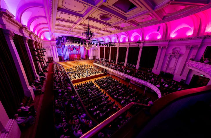 A decadent, pink lighted theatre houses Auckland Phil playing to a live audience.