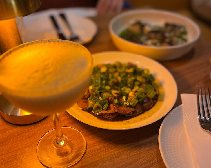 A mocktail and Bar Magdaâs iconic steak dish sit alongside at a table