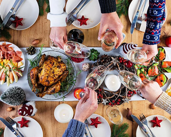 A Christmas feast from Birds Eye view shows hands reaching to grab food and drink on a table