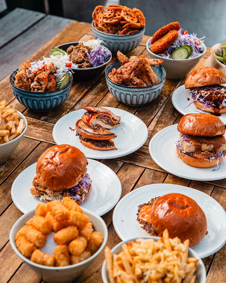 An array of dishes such as burgers, fries and fried chicken from Karaage Boy and Hash n Smash from Side Hustle Barâs pop-up kitchen series