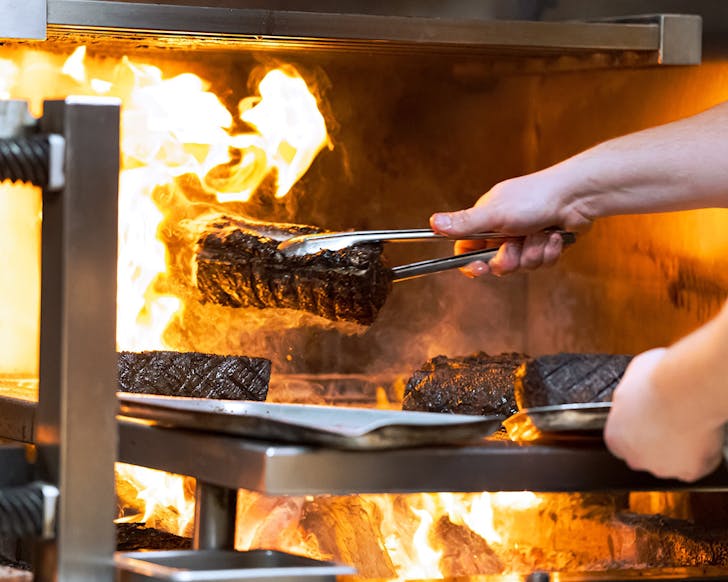 Steaks being seared off at Jardin Grillâs signature woodfire at Sofitel Wellington