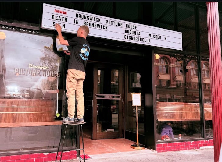 setting up sign at Brunswick picture house