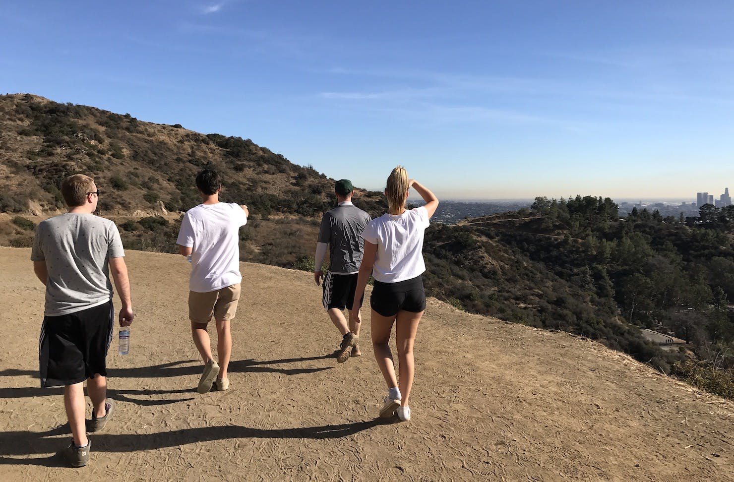 A group of four people hikes along a hilltop.