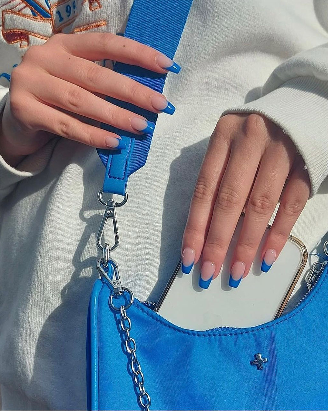 It's all blue and white as someone puts their phone in their bag using blue tipped nails at Inco studio in Ponsonby.