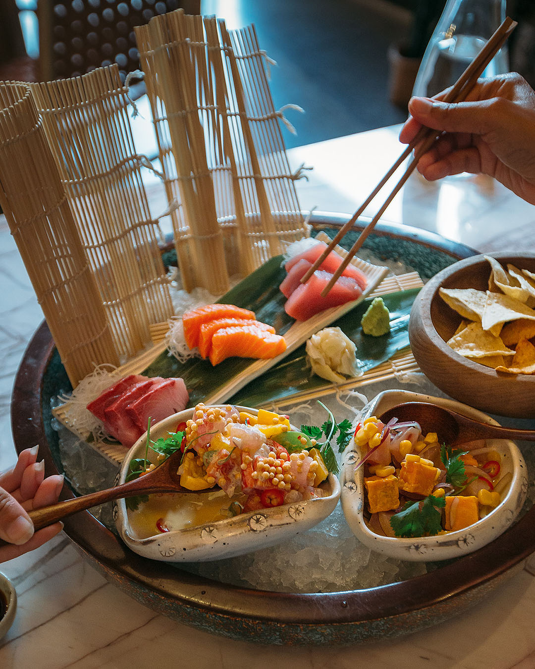 Hands dive into a sashimi platter at INCA, one of the best restaurants in Ponsonby.