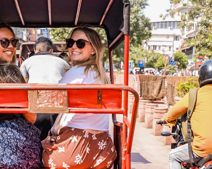 Two women in the back of a tuk-tuk.
