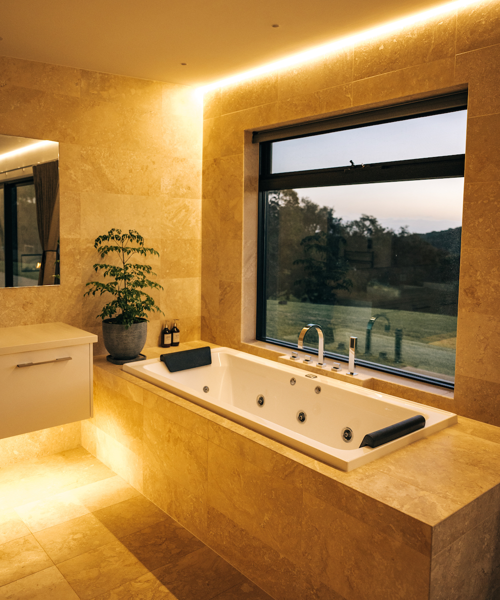 a bathtub with a window looking out to the countryside