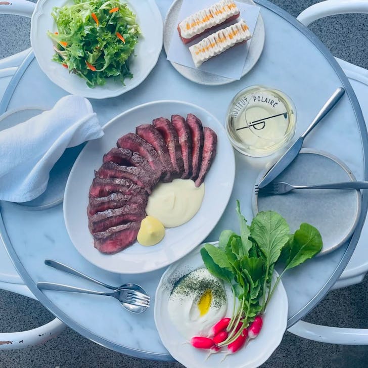 Plates of food and wine on table.