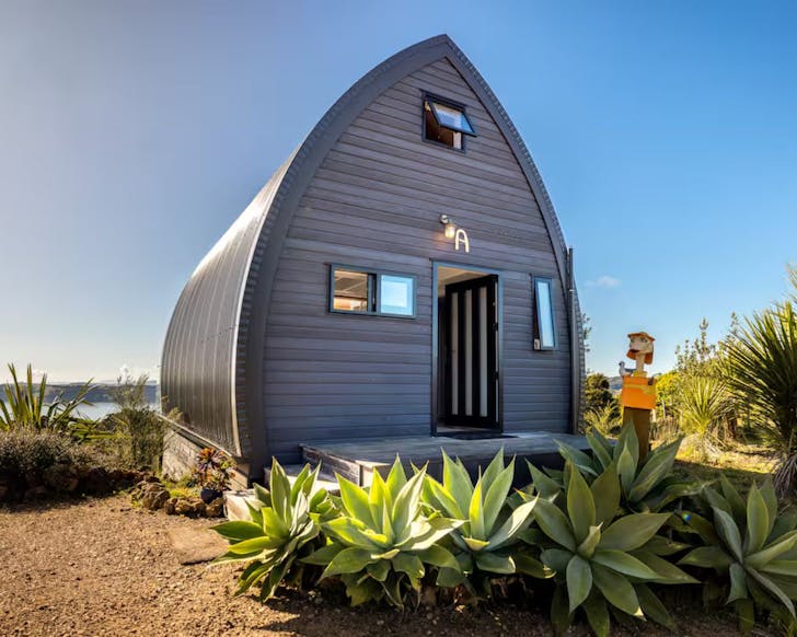 The blue sail-shaped exterior of Island Chalet romantic Airbnb near Auckland