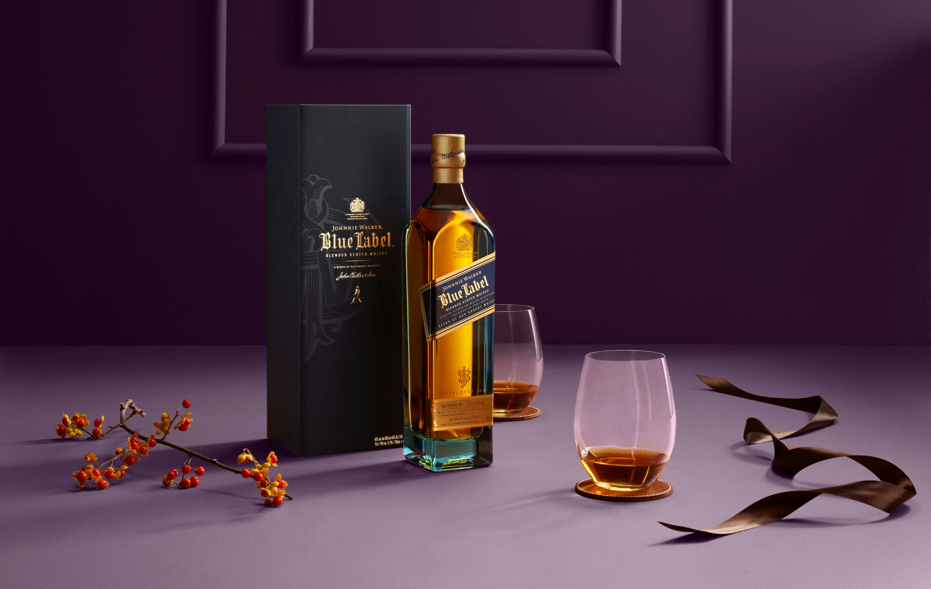 Johnnie Walker Blue on a purple background with 2 glasses and christmas decorations