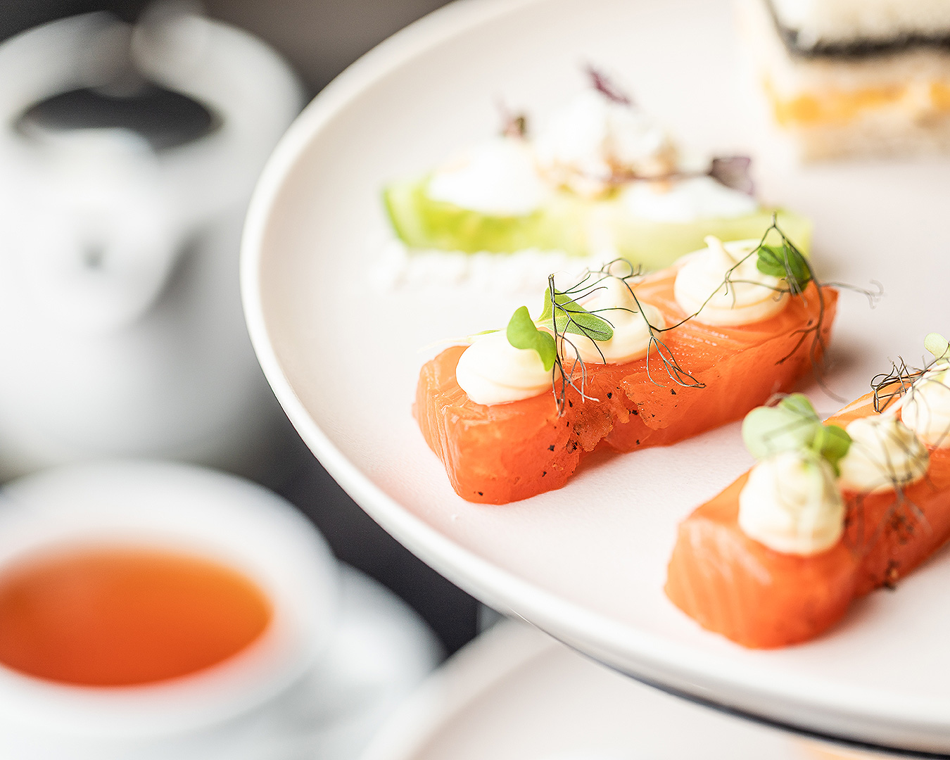 A close up of some salmon with tea in the background at JW Marriott's Afternoon High Tea in Auckland.