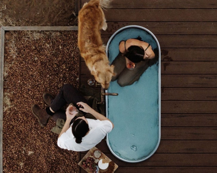 Two people at the outdoor bath at Jack The Dog Friendly Cabin one of the best romantic WA getaways